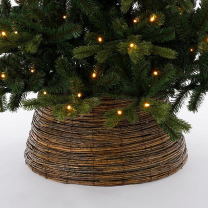 Wilgentakken kerstboommand onder versierde boom – natuurlijke en rustieke basis voor je kerstdecoratie.