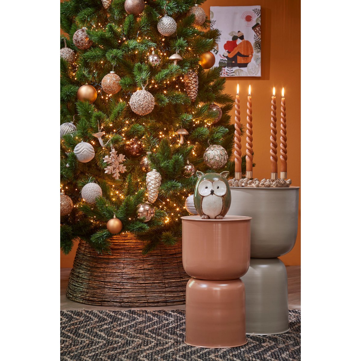 Gezellige kerstsetting met natuurlijke rotan boommand – warme en sfeervolle uitstraling in huis.