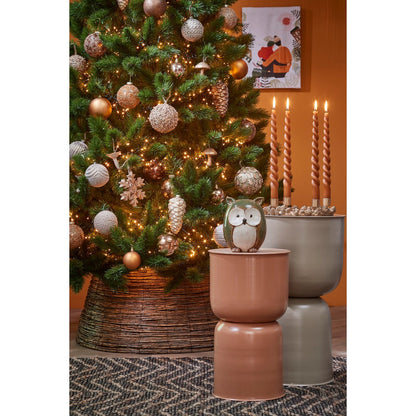 Gezellige kerstsetting met natuurlijke rotan boommand – warme en sfeervolle uitstraling in huis.