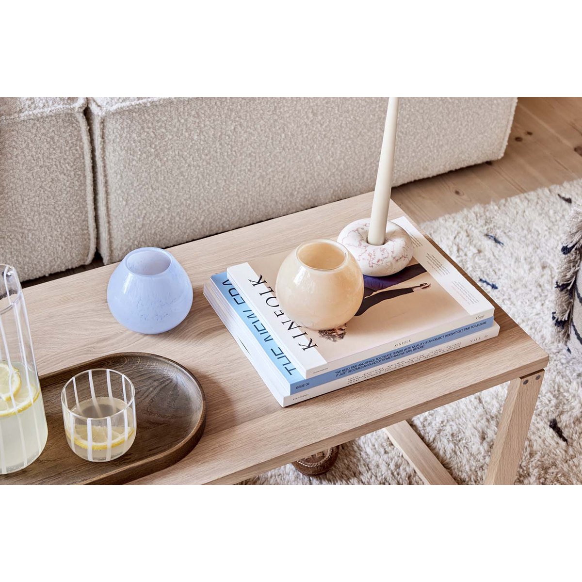 De marmeren witte kandelaar met zachte beige aders vormt hier een elegant accent op een salontafel. Het gladde ronde design combineert prachtig met natuurlijke materialen zoals hout en glas, en geeft de ruimte een verfijnde, serene uitstraling.