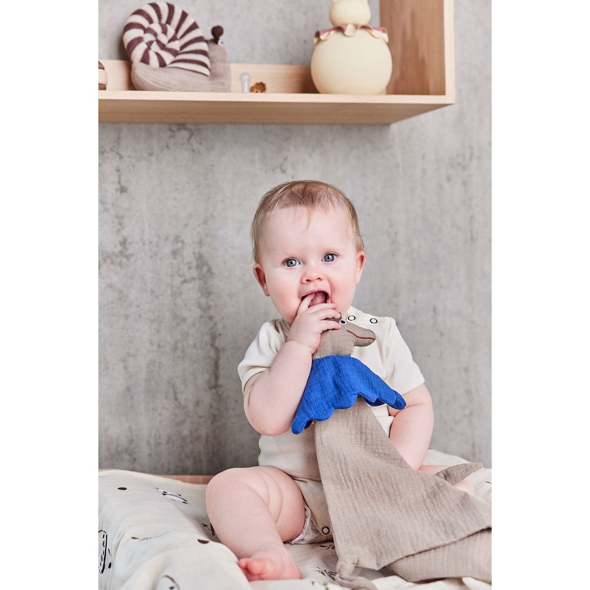 Kind speelt in de kinderkamer met het konijn-nachtlampje zichtbaar op de achtergrond.