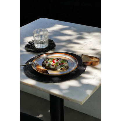 Kralen placemat zwart 30 cm met daarop een bord met lekker eten
