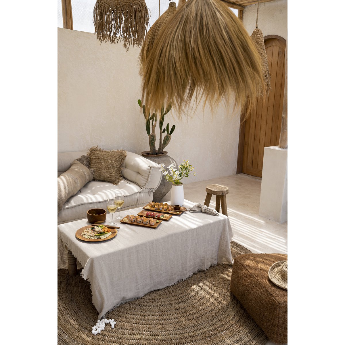 Linnen tafelkleed beige 150x150 cm in een boho binnenruimte met borrelplanken en glazen wijn