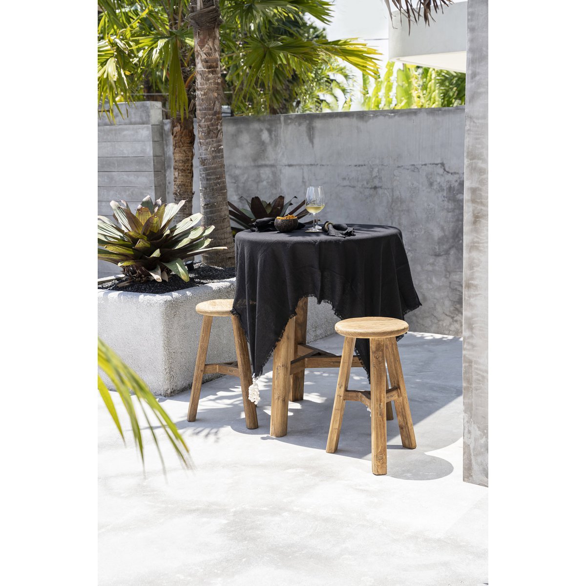 Linnen tafelkleed zwart 150x150 cm in een tuin over houten ronde tafel met glazen en schalen