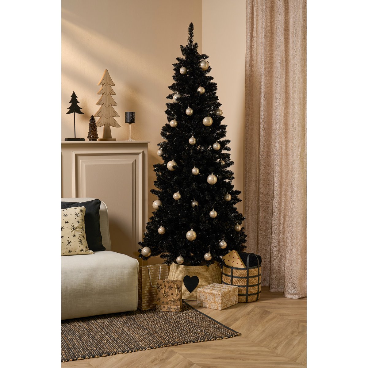Zwarte kerstboom met rotan mand met hartmotief – modern en warm kerstinterieur in neutrale tinten.