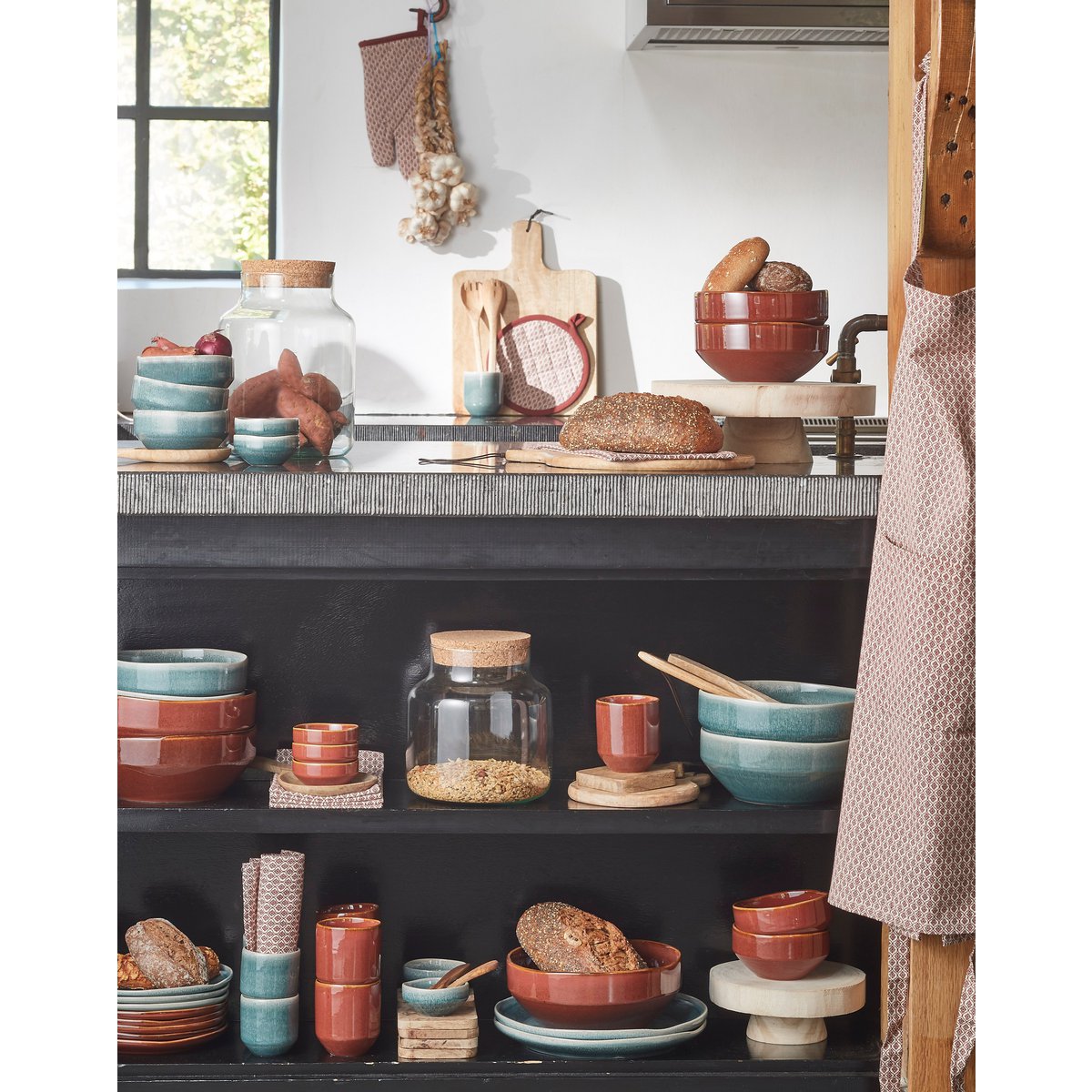 Sfeershot van serveerplank in keukenruimte met servies en accessoires.