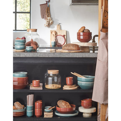 Sfeershot van serveerplank in keukenruimte met servies en accessoires.