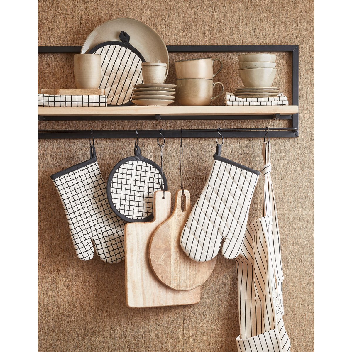 Serveerplank hangend aan een wandrek met keukenaccessoires.