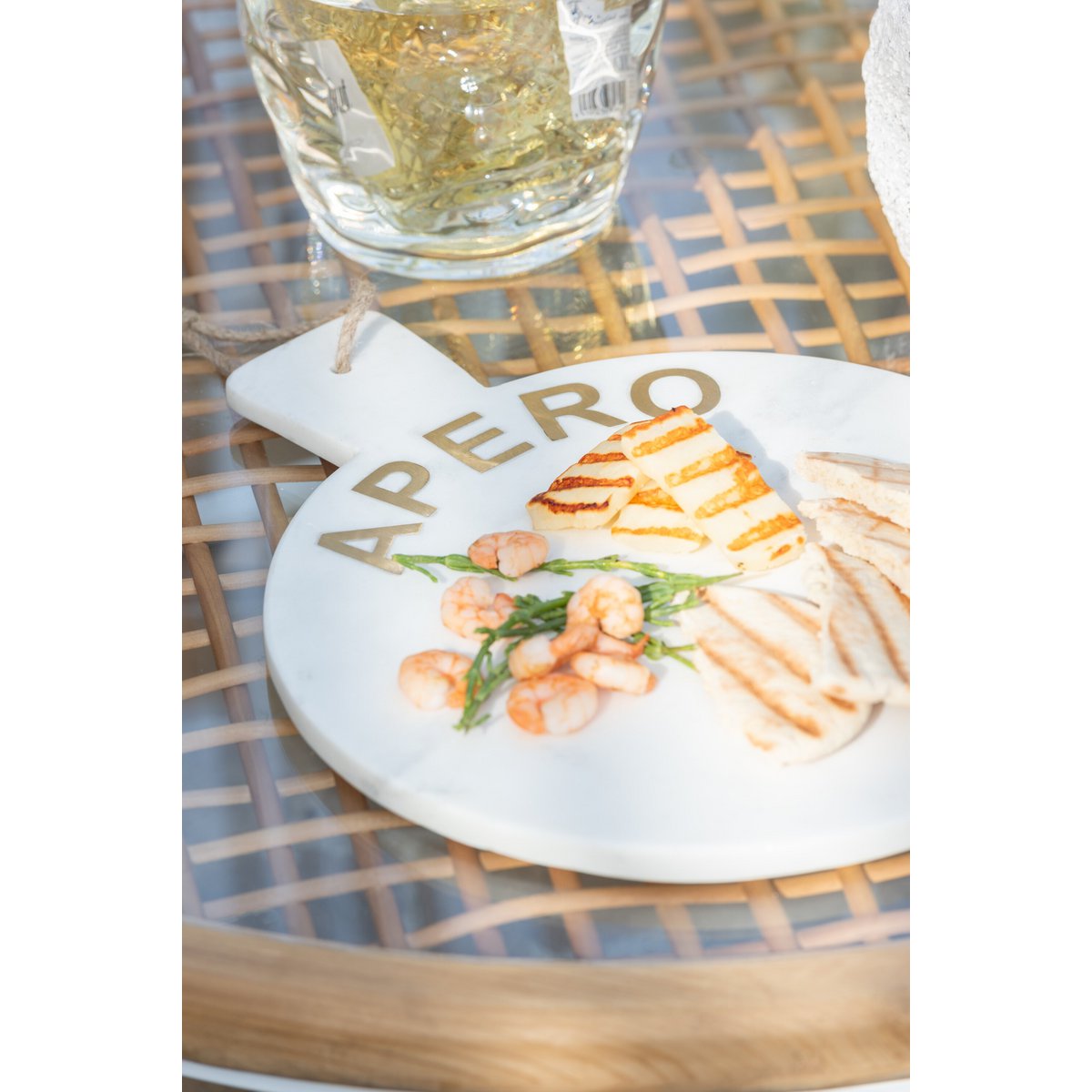 Marmeren ronde witte serveerplank Apero op een tafel met lekkere hapjes erop