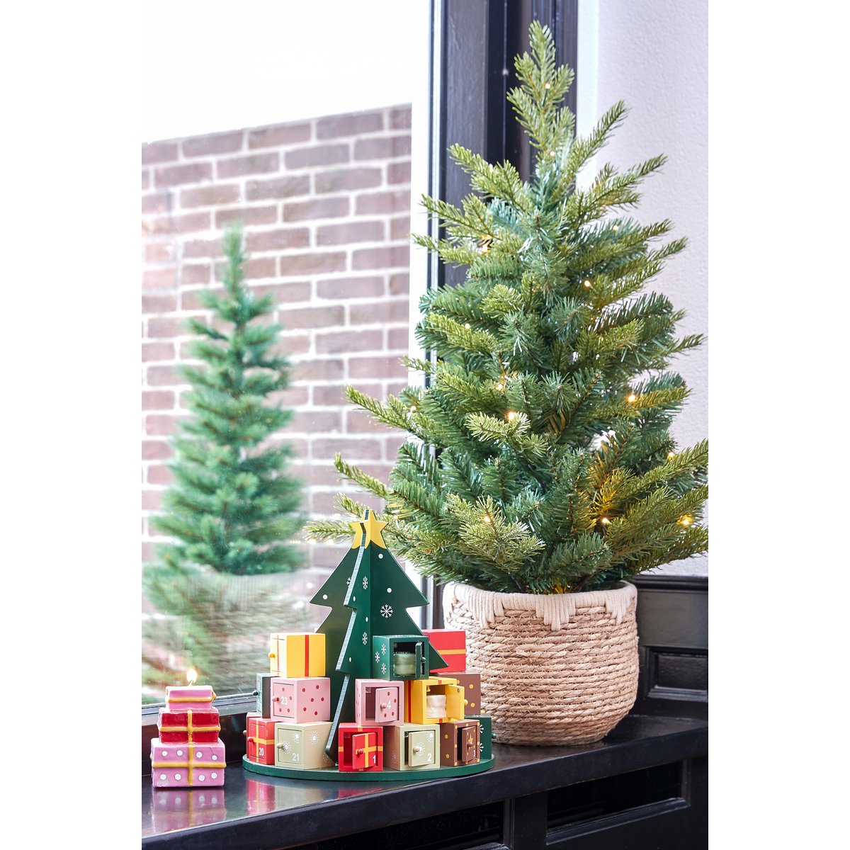 Meerkleurig MDF adventkalender met 24 vakjes in een sfeervol interieur omringd met kerstcadeautjes en kersbtomen.