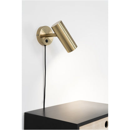 Messing Paris wandlamp gemonteerd boven een nachtkastje