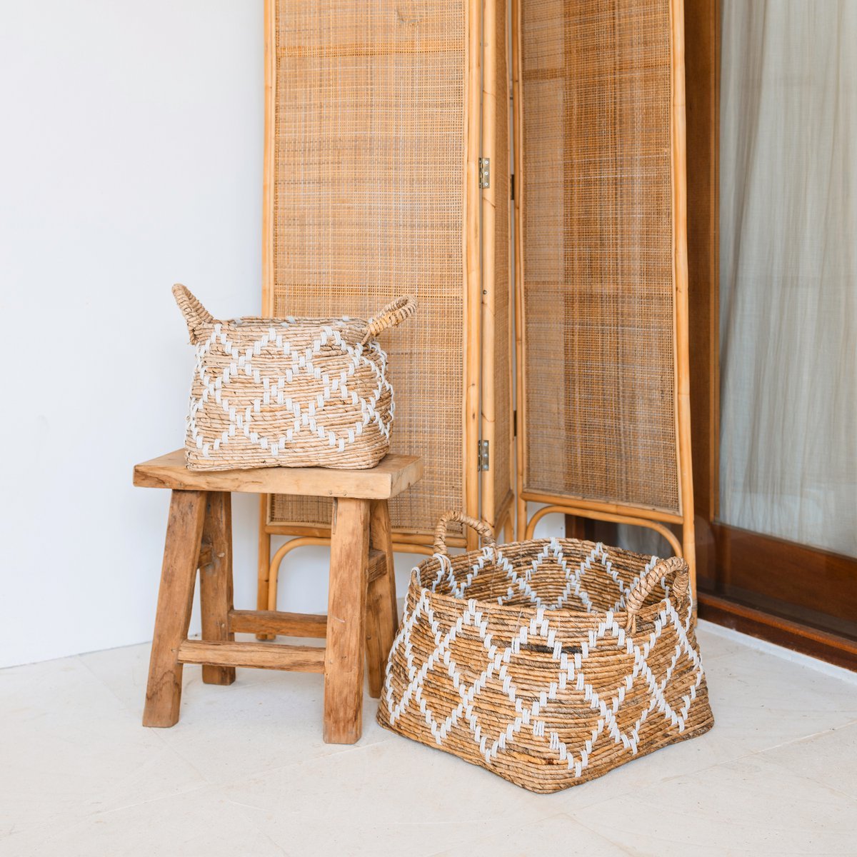 Obergmand vierkant naturel met handvatten Gandaria met een andere Gandaria mand op een houten kruk met boho decoratie op de achtergrond