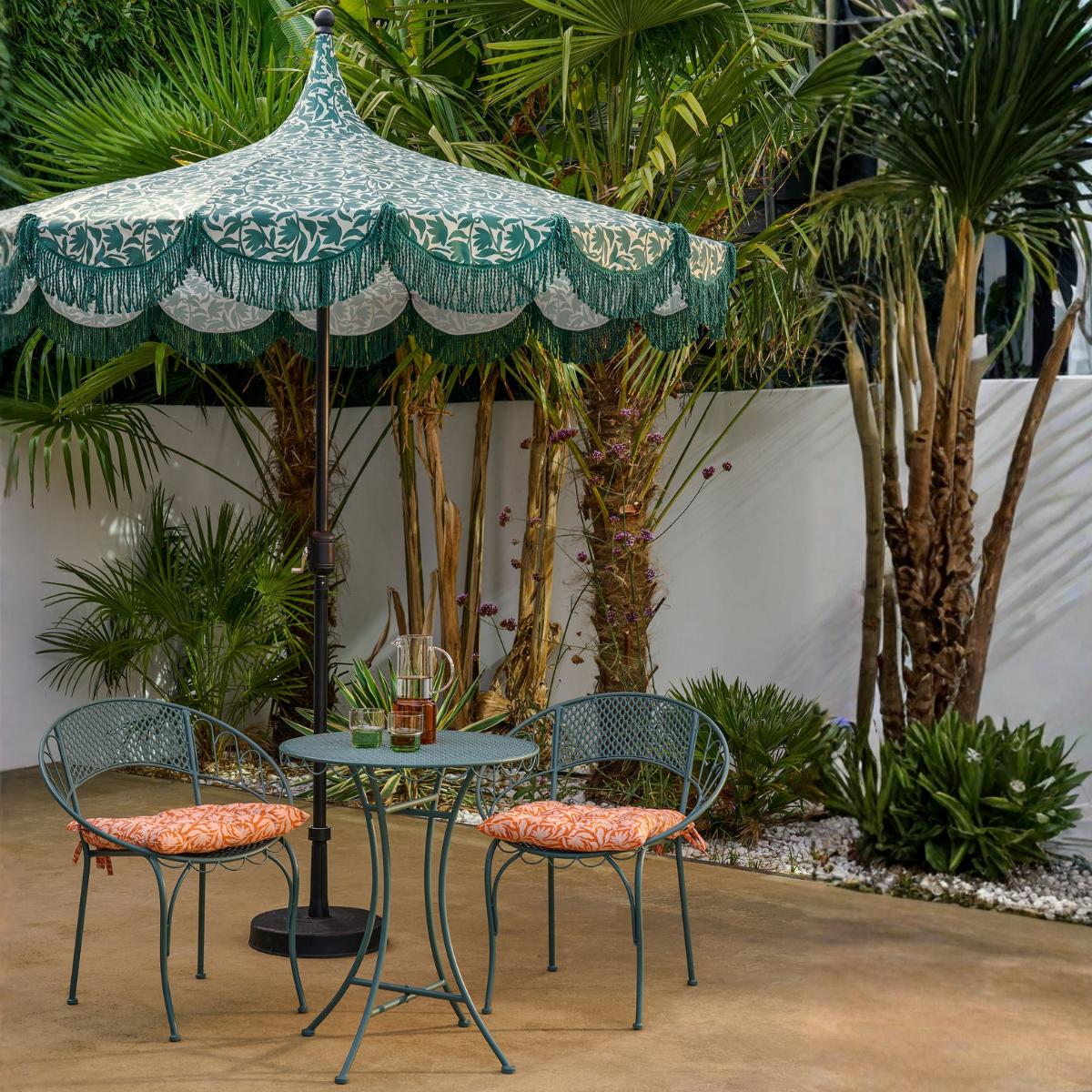 Parasol groen met franjes 235 cm buiten in een tuin boven een groen bistro tuinset, een waterkan en twee glazen op het tafeltje