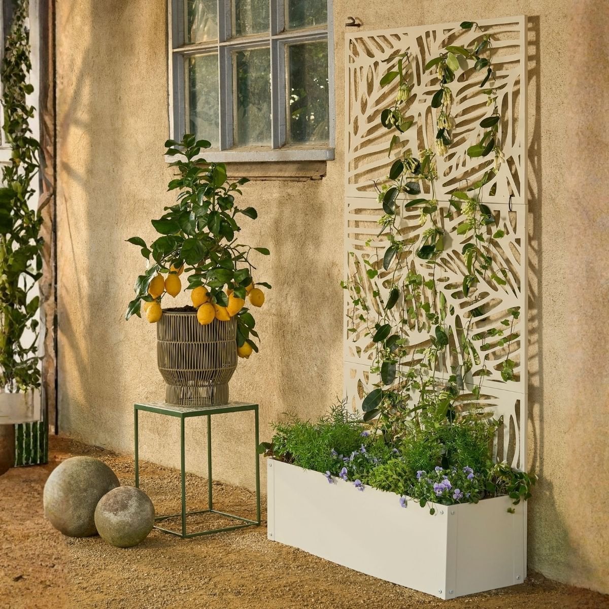 Plantenbak met klimrek gebroken wit metaal 174 cm Sapri in een knusse tuin met meerdere planten en bloemen in verschillende plantenbakken