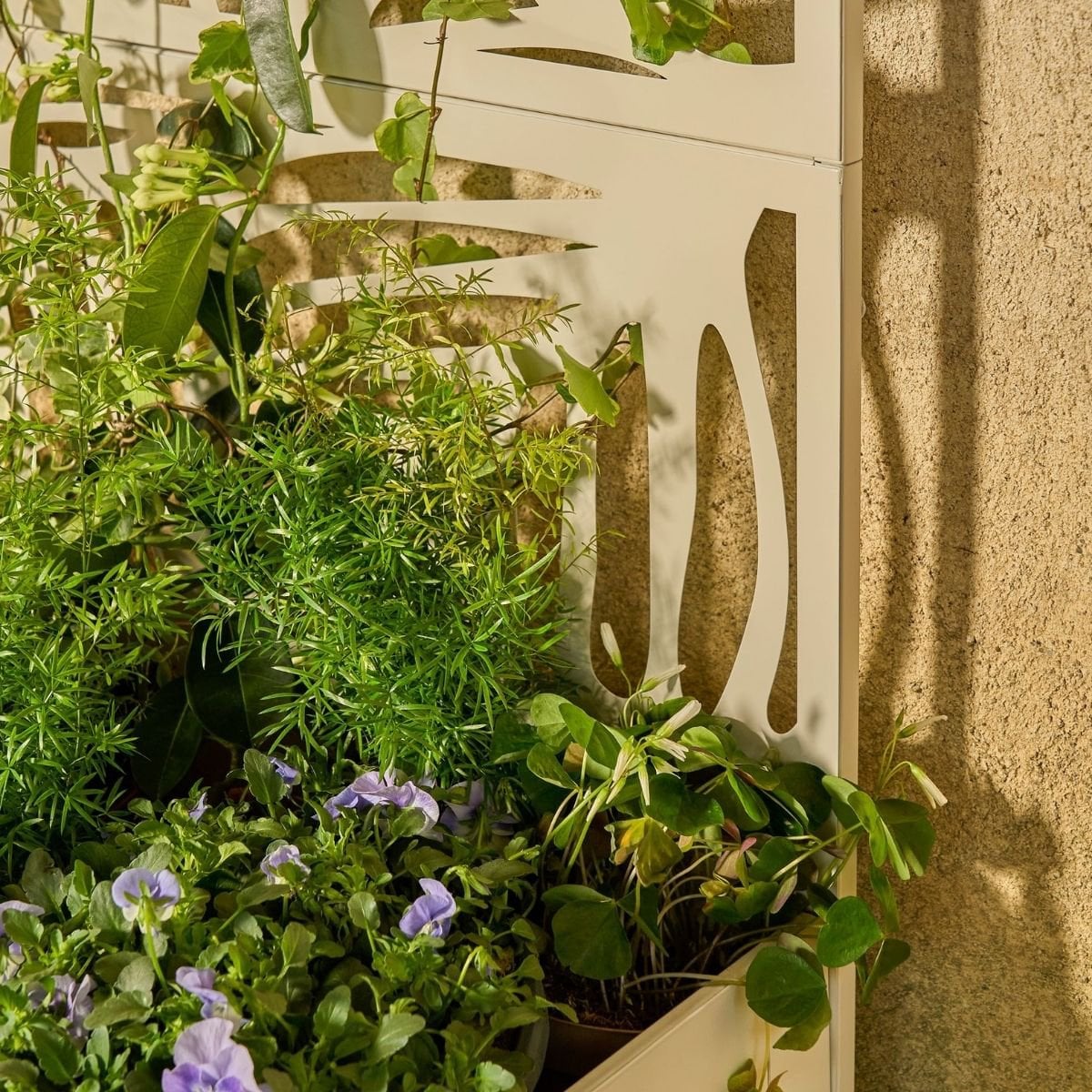 Plantenbak met klimrek wit metaal 180 cm Sapri in tuin, closeup van het motief op het rek maar daaraan groene planten en bloemen