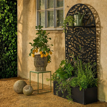 Plantenbak met klimrek zwart metaal 180 cm Sapri met bladerenmotief, in een knusse tuin met meerdere planten en plantenbakken