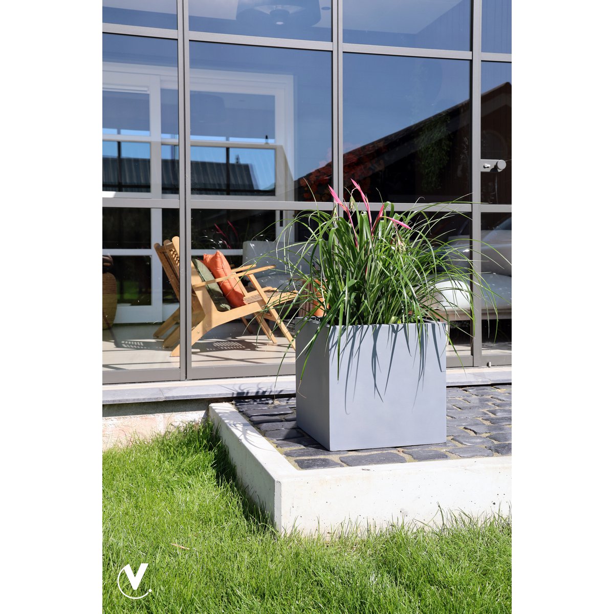 Plantenbak voor buiten in grijs fiberstone El Salvador, in een moderne tuin op tegel met planten erin