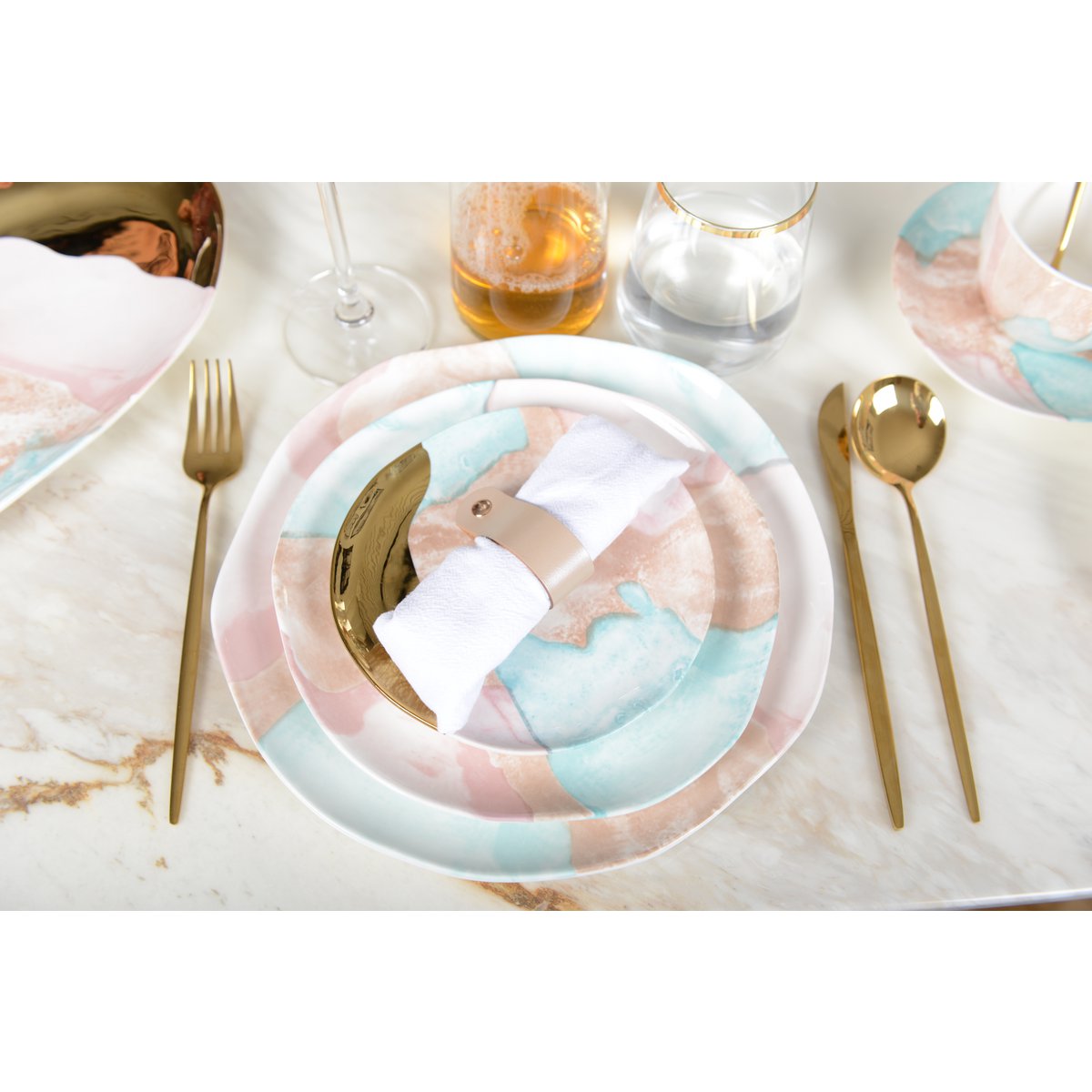 Porseleinen bord goud roze blauw Treasure Mine op een gedekte tafel, met andere treasure mine borden en bijpassend gouden bestek