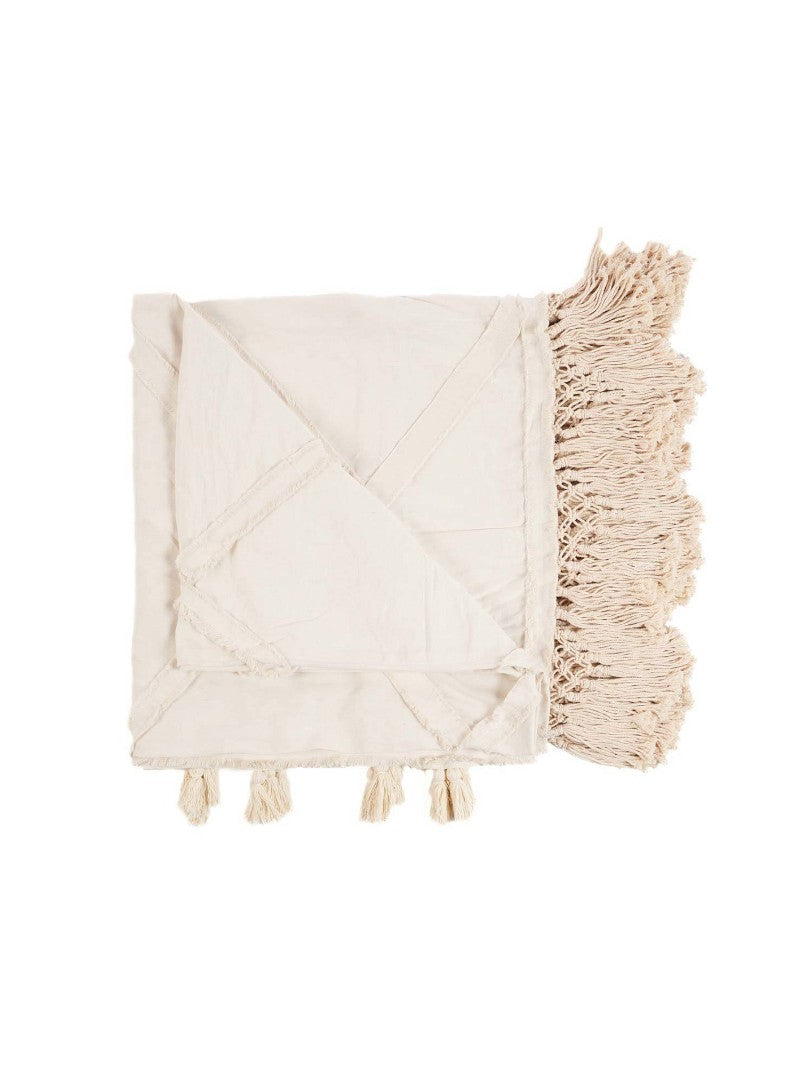 Beige katoenen plaid met sierlijke franjes en kwastjes, een zacht en decoratief woonaccessoire dat warmte en textuur toevoegt aan je interieur, perfect voor op de bank of het bed in een natuurlijke en bohemian woonstijl.