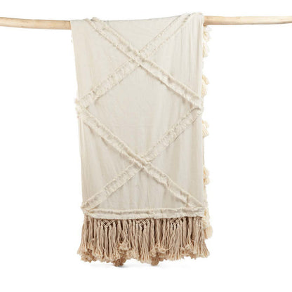 Beige katoenen plaid met sierlijke franjes en kwastjes, een zacht en decoratief woonaccessoire dat warmte en textuur toevoegt aan je interieur, perfect voor op de bank of het bed in een natuurlijke en bohemian woonstijl.