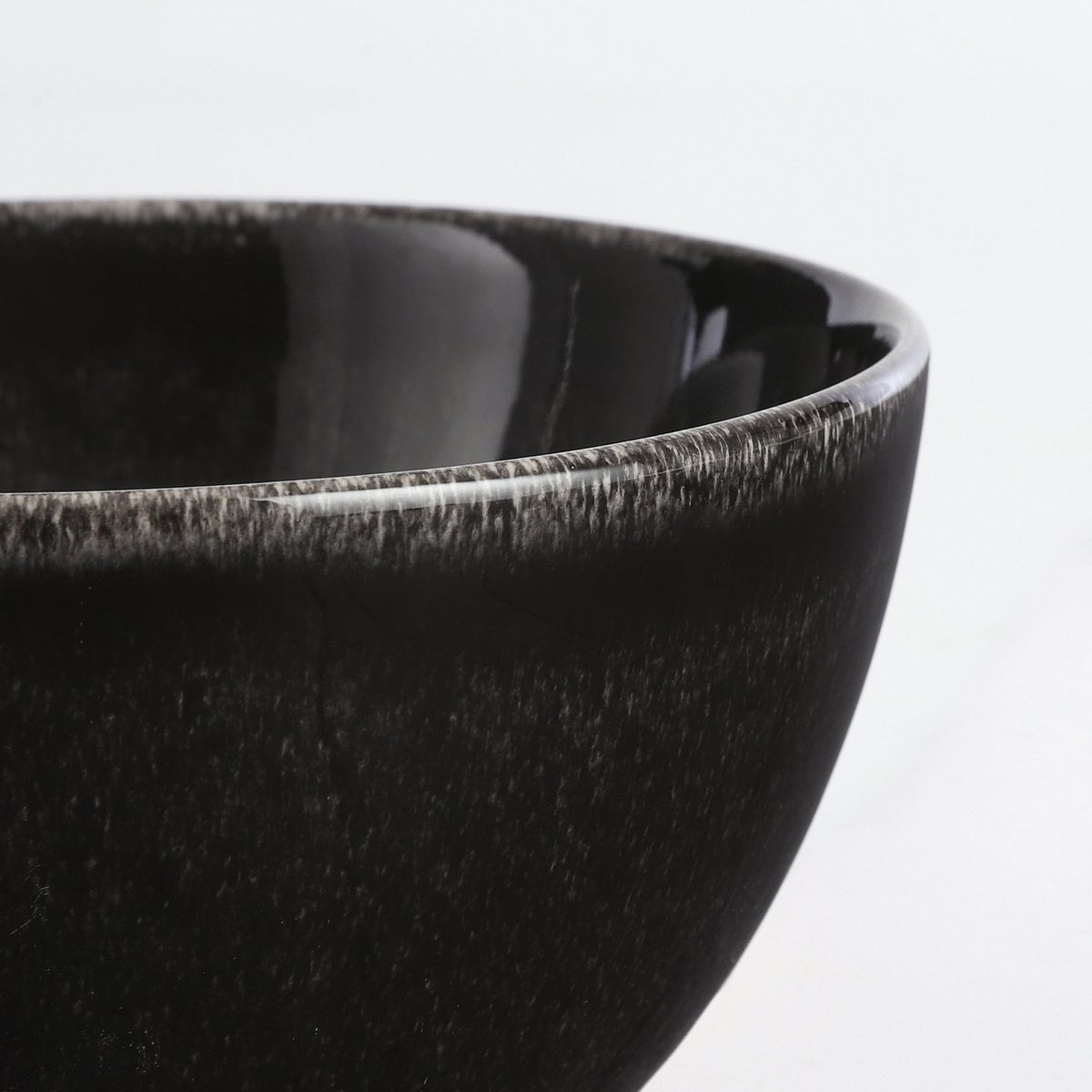 Rand van een kom van de keramieken serviesset zwart 16-delig voor 4 personen Tabo
