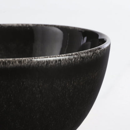 Rand van een kom van de keramieken serviesset zwart 16-delig voor 4 personen Tabo