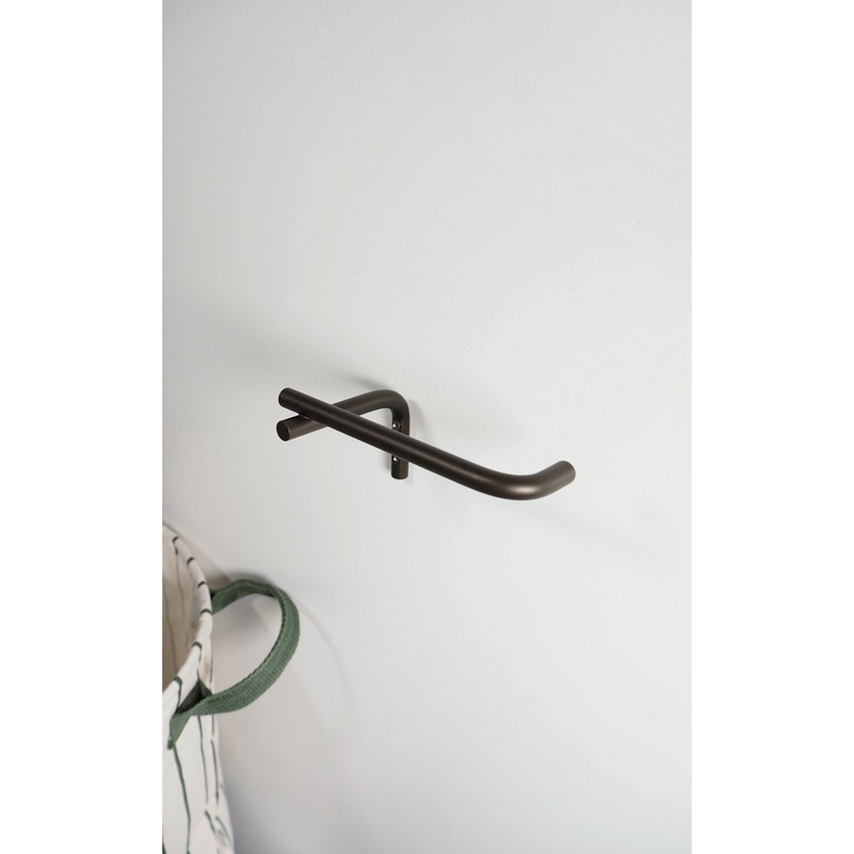 Strakke metalen wandhaak in bronskleur – minimalistische accessoire voor interieur en badkamer.