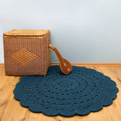 Rond vloerkleed blauw Alma van katoen naast een instrument en een rotan mand