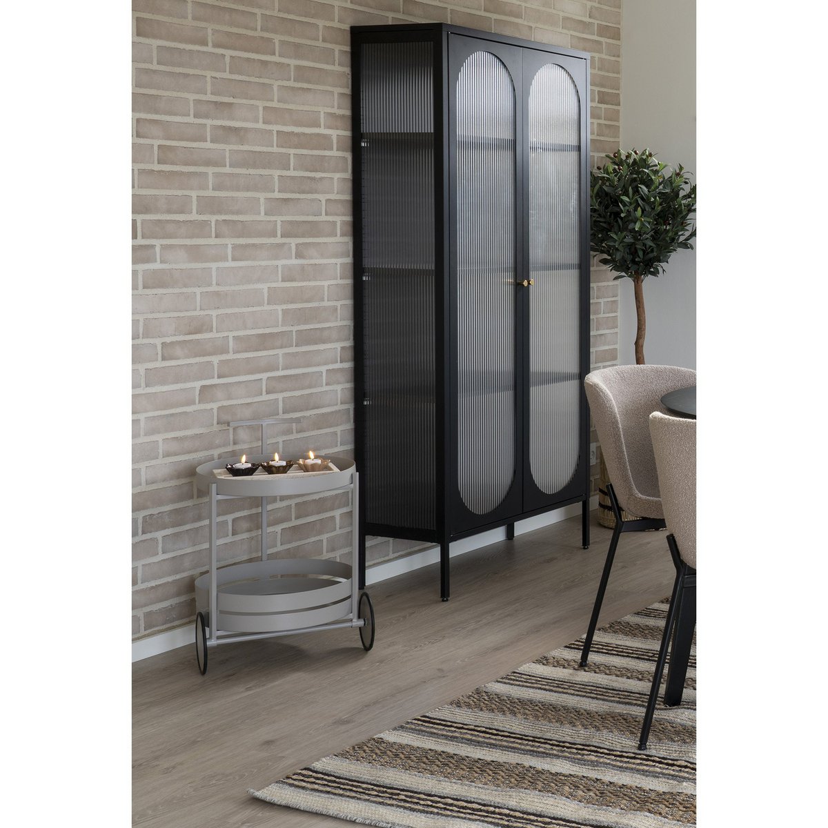 Ronde serveerwagen op wielen in grijs van staal 2 lagen 61 cm met kaarsjes in een modern interieur