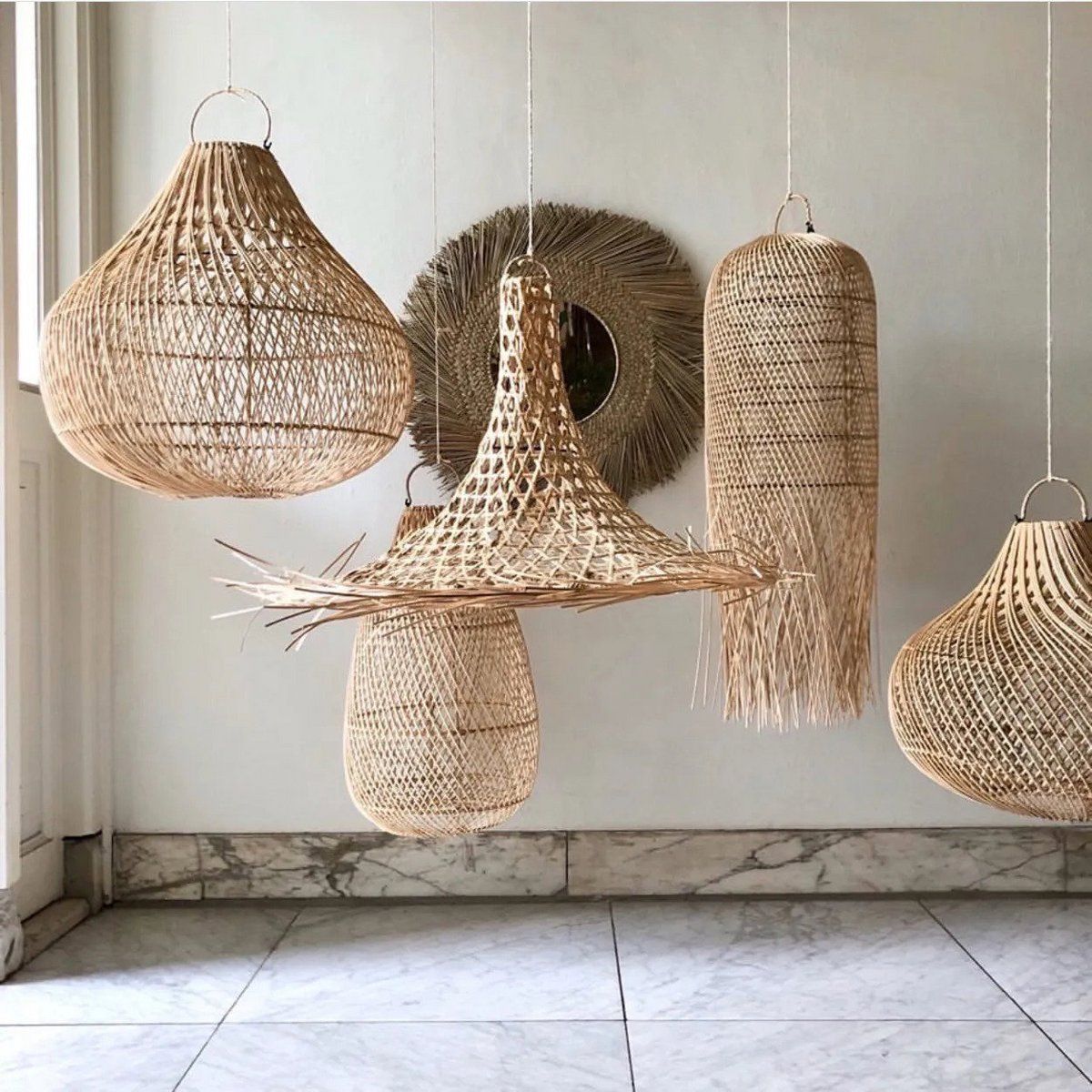 Handgemaakte rotan hanglamp in Coastal Boho stijl. Zorgt voor warm, zacht licht en een boho uitstraling. Hier samen met een paar andere boho hanglampen.