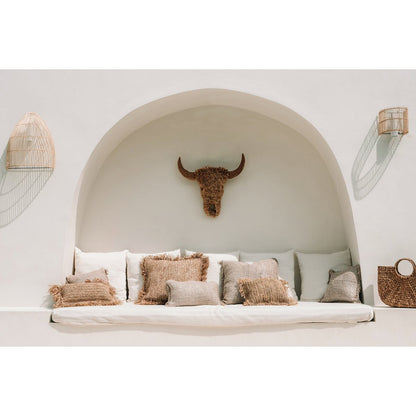 Rotan wandlamp Lalo als sfeerelement boven een witte zithoek
