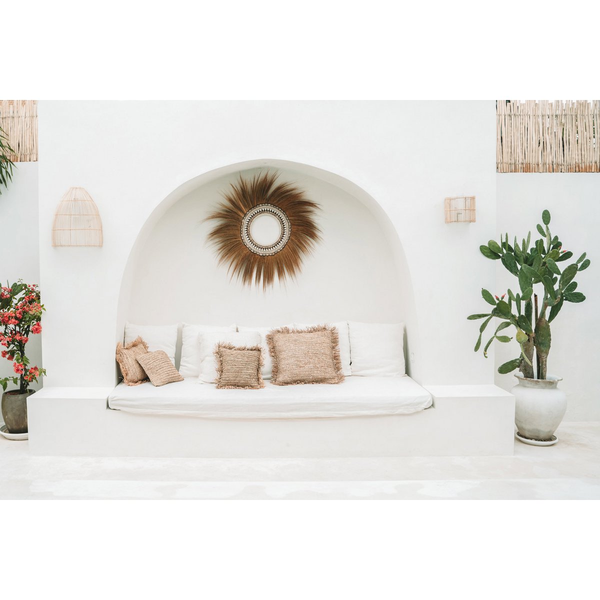 Witte loungehoek met rotan wandlampen voor mediterrane sfeer