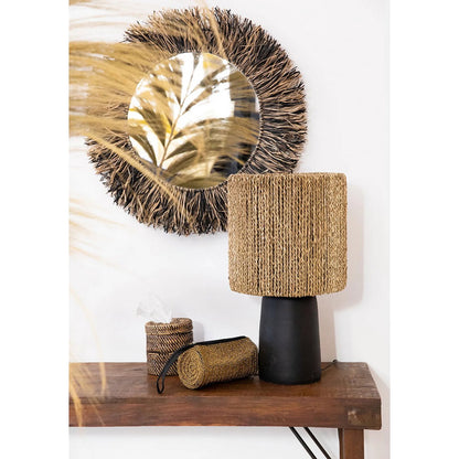 Rotan tissuehouder naturel rond met deksel in een boho hal op houten tafel naast andere rotan woonaccessoires