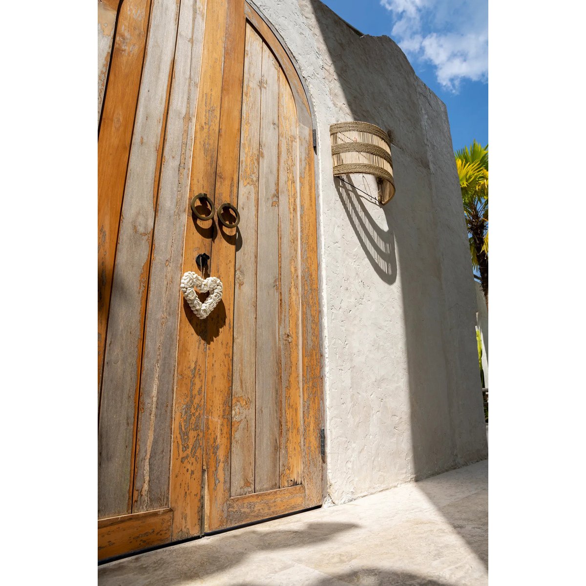 Gezellige boho interieurhoek met Doedoe rotan wandlamp aan de muur