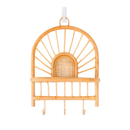 Handgemaakte rotan wandplank met plankje en haken aan een witte muur