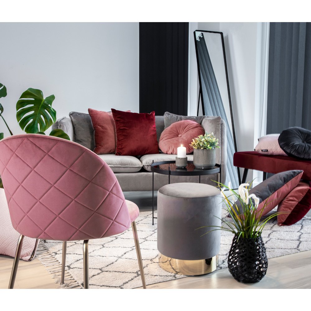 Roze fluwelen eetkamerstoel met goudkleurige poten in een moderne woonkamer met velvet accenten en warme tinten. Een stijlvolle en comfortabele stoel die elegantie en zachtheid toevoegt aan het interieur.