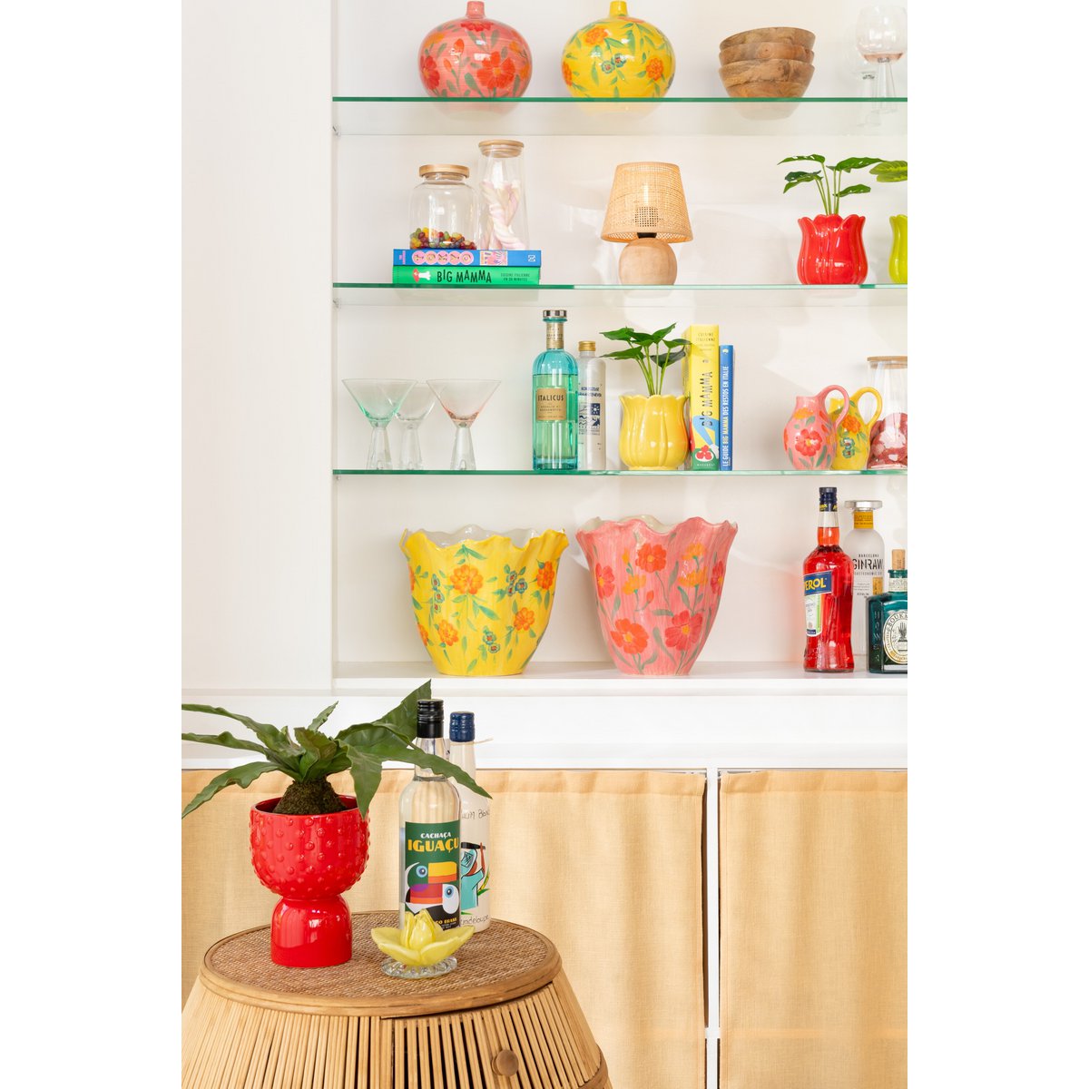 Roze keramieken vaas gestyled in kast met woonaccessoires