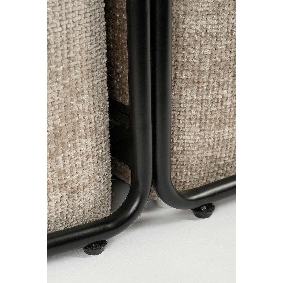 Closeup van een moderne salontafel met een ovale houten bovenkant en twee zachte beige poefs geïntegreerd in een zwart metalen frame. De poefs kunnen los worden gebruikt als extra zitplaatsen of voetenbankjes. Een stijlvolle en multifunctionele toevoeging aan elk eigentijds interieur.