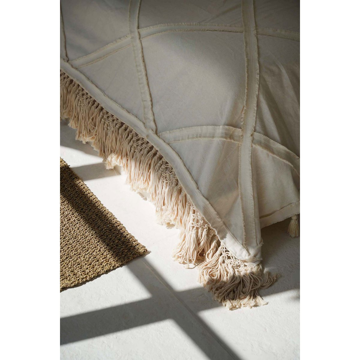 Beige katoenen plaid met sierlijke franjes en kwastjes, een zacht en decoratief woonaccessoire dat warmte en textuur toevoegt aan je interieur, perfect voor op de bank of het bed in een natuurlijke en bohemian woonstijl.