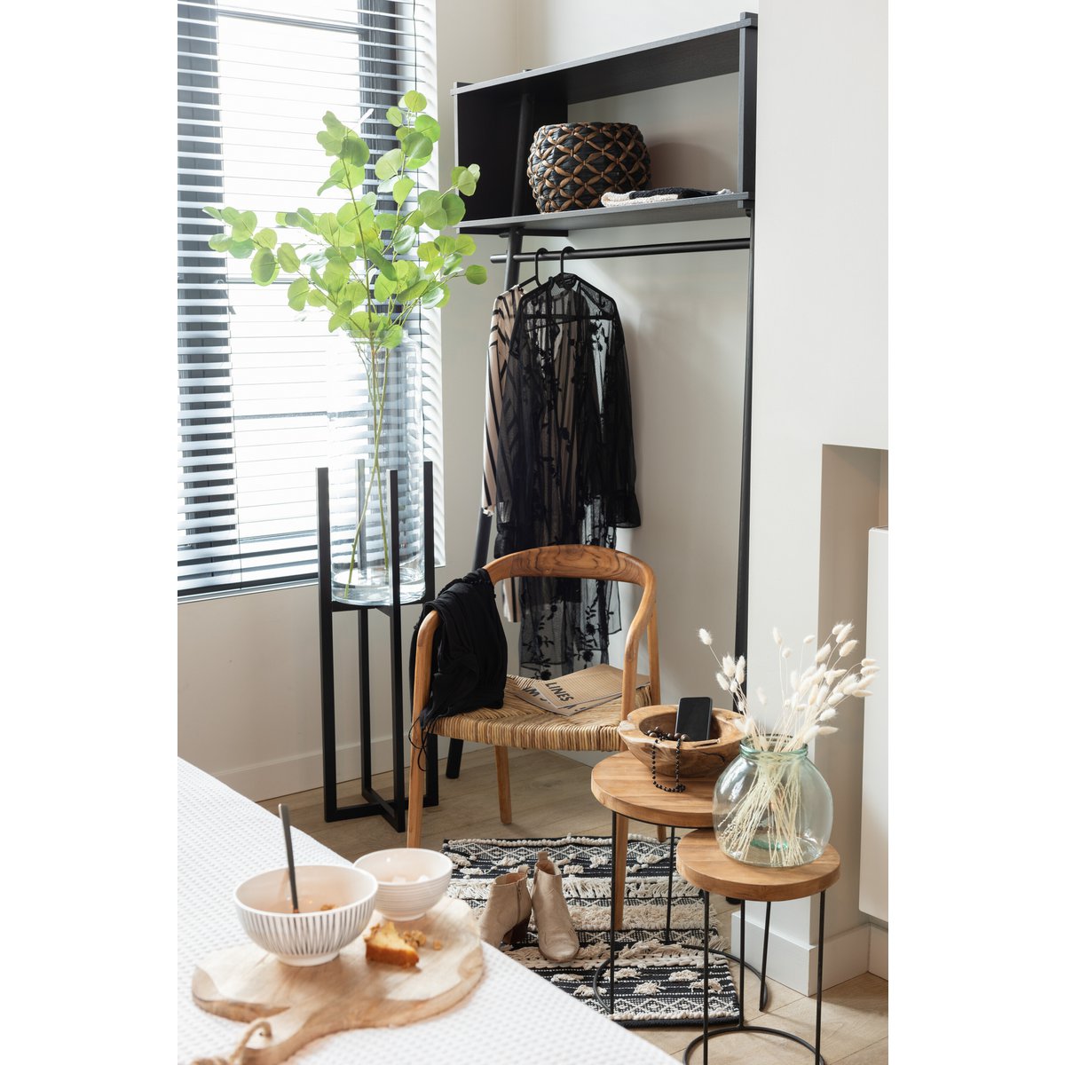 Sfeervolle hoek in huis met plantenstandaard zwart en houten details
