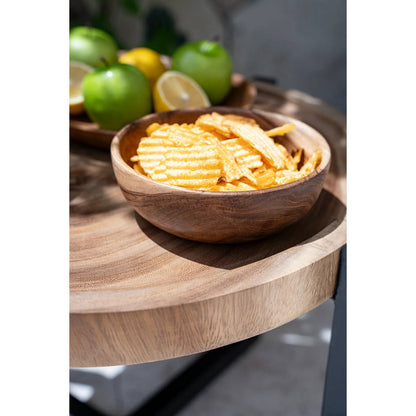 Teakhouten kom met snacks op een houten bijzettafel
