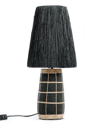 Zwarte terracotta tafellampvoet met rotan kap op witte achtergrond