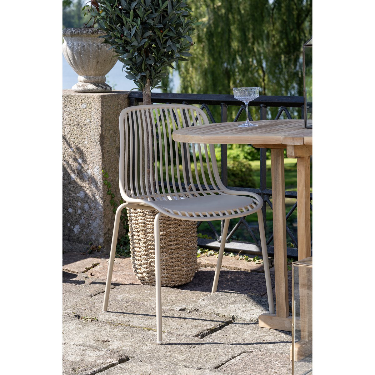 Tuinstoel beige 55x82 cm set van 4 Branson Garden buiten in de tuin aan een houten tafel met een cocktail glas erop