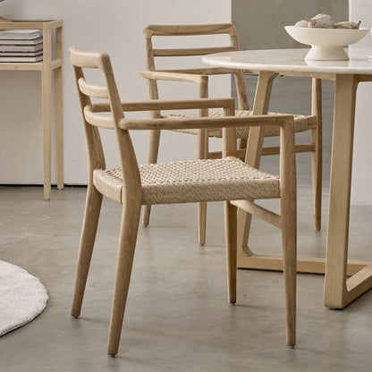 Tuinstoel teak in naturel Verano binnen in een natuurlijke eetkamer met andere houten stoelen en tafels
