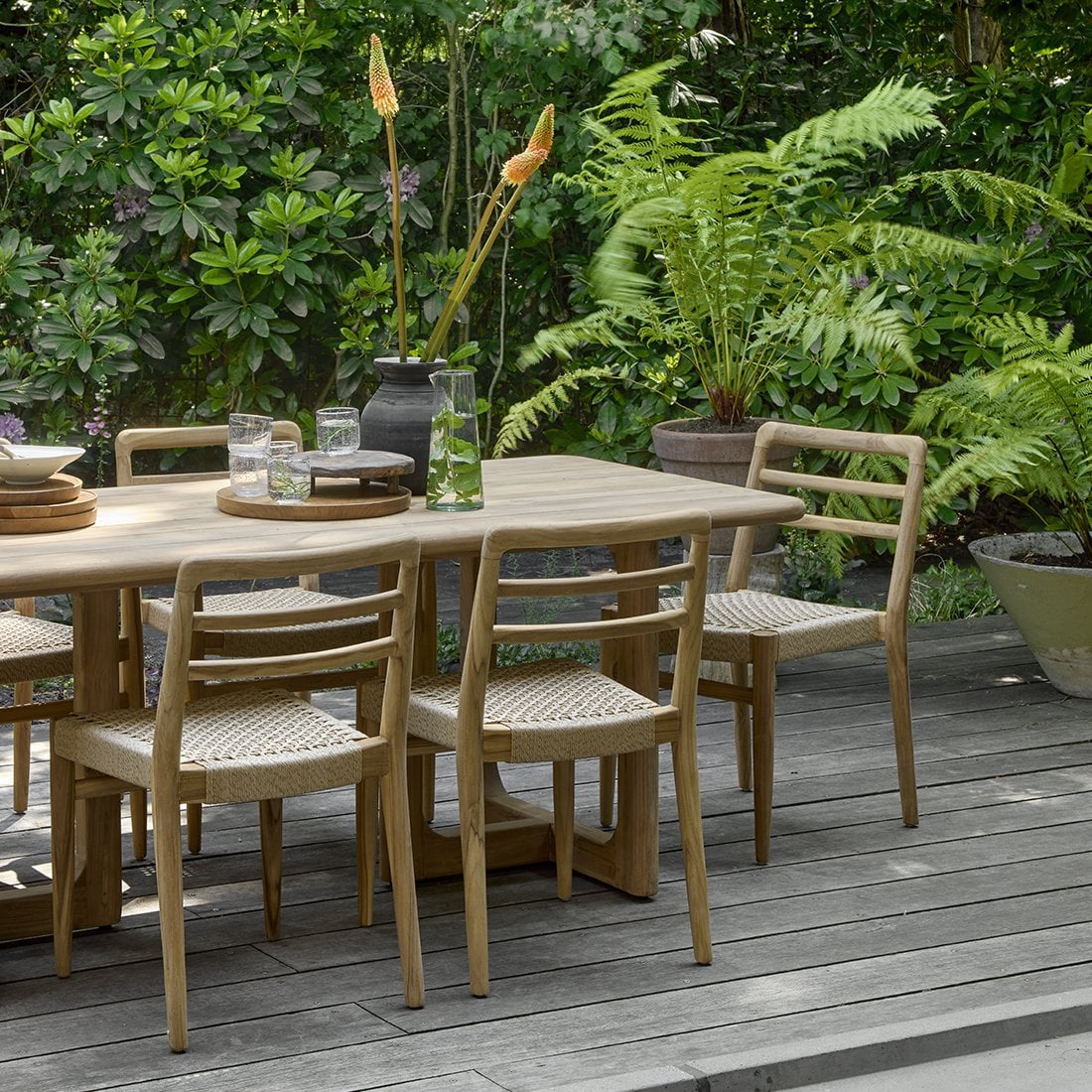 Tuinstoel teak in naturel Verano in tuin op houten veranda aan tafel met andere stoelen 