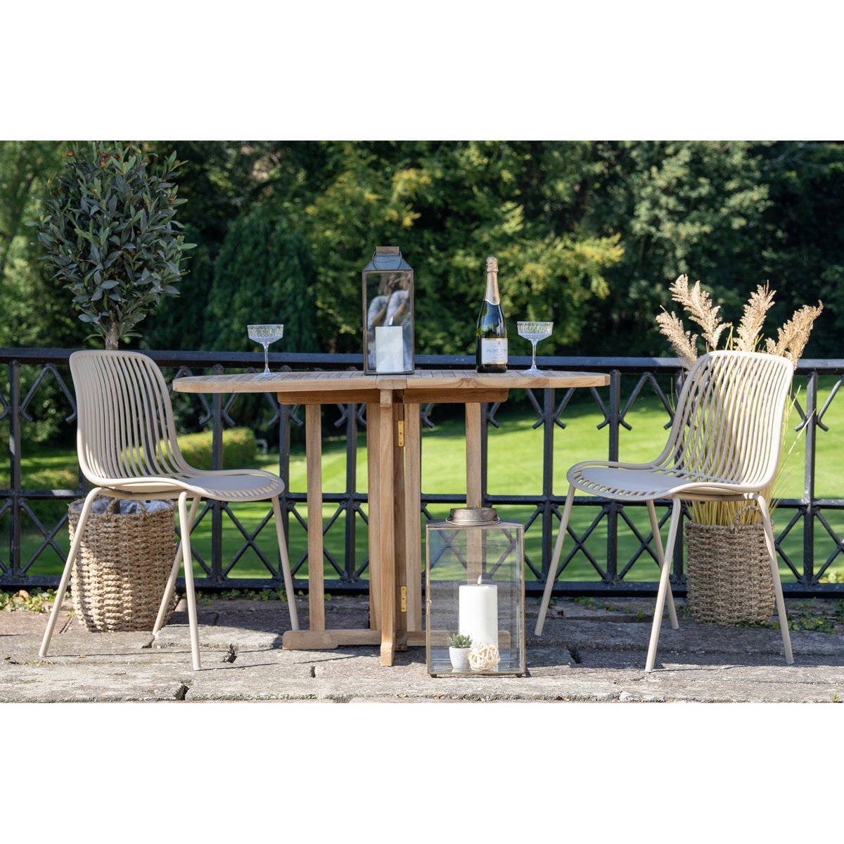 Twee tuinstoelen beige 55x82 cm set van 4 Branson Garden aan een tafel met  wijnglazen en een wijnfles op een terras