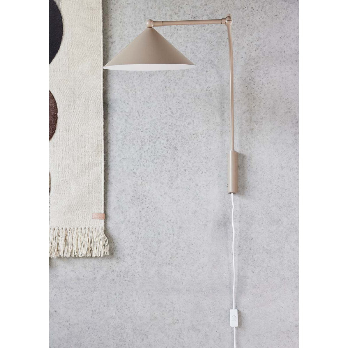 Wandlamp wit Kasa met verstelbare arm tegen grijze muur aan naast muurtapijt