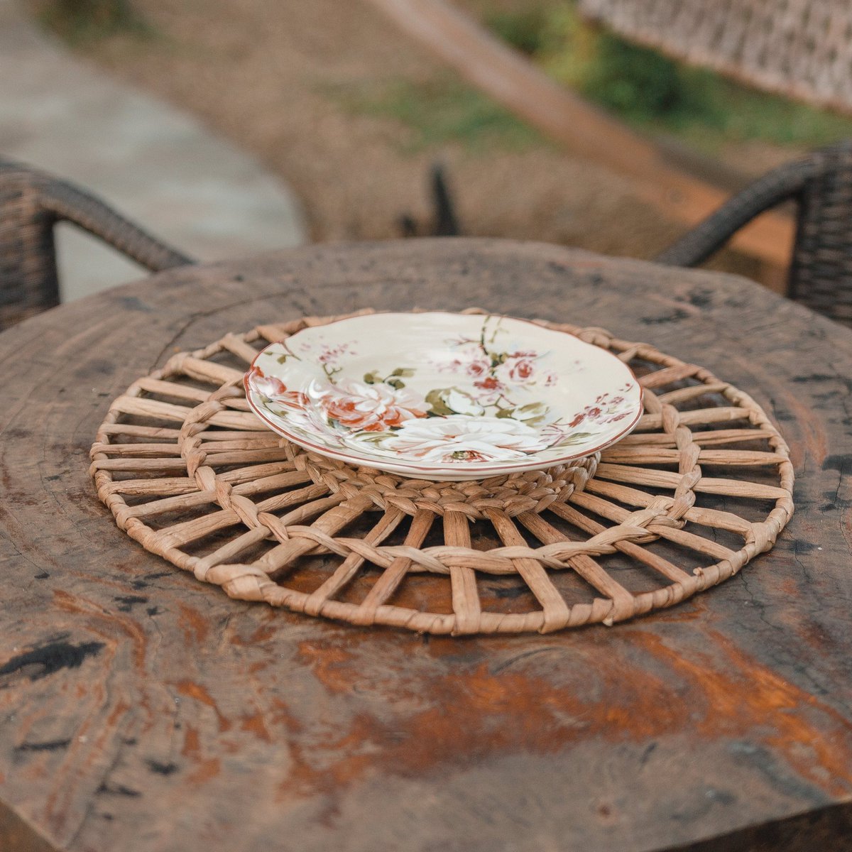 Waterhyacint placemat rond naturel 38 cm set van 2, 4 of 6 Caruban buiten op een roestige tafel met een mooi vintage bord erop
