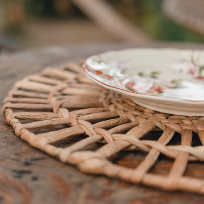 Waterhyacint placemat rond naturel 38 cm set van 2, 4 of 6 Caruban closeup buiten op een roestige tafel met een mooi vintage bord erop