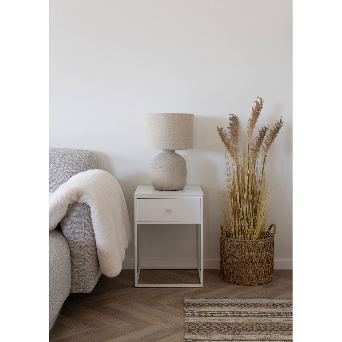 Witte Vita nachtkatje naast een fauteuil in een modern interieur